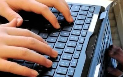 Oppilaan kädet tietokoneen näppäimistöllä.