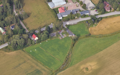 Viistoilmakuva Lokalahden keskustasta. Kuvassa peltoja, tie sekä Lokalahden koulu