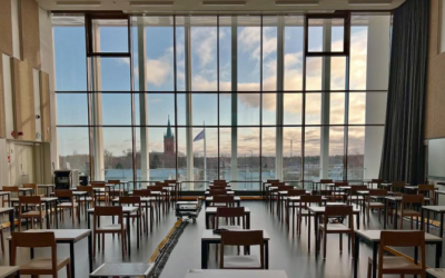 Rauhasali kuvattuna kaupungin suuntaan. Etualalla paljon yhden istuttavia pöytiä ja tuoleja. Taustalla aurinkoinen kaupunkimaisema ja Uusi kirkko.