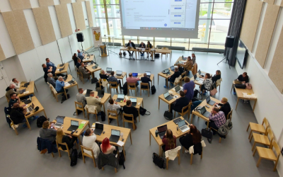 Edessä uusi kaupunginvaltuusto kuvattuna takaapäin. Valtuutetut 37 kpl istuvat pöytäryhmissä ja katsovat eteenpäin.