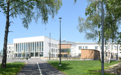 Uudenkaupungin monitoimijatalo Wintterin näyttävä julkisivu, etualalla kesäisiä koivun oksia.