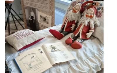 vanhat tonttunuket museossa sängyn päällä.