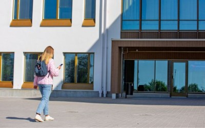 Nuori kävelee kohti Wintterin koulua ja katsoo kännykkää. 