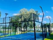 Padelkenttä ulkona taustalla puita ja kaupunginlahti veneineen