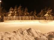 Etualalla luistelukenttä, taustalla luistelukaukalo, talvinen iltakuva