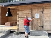 kuvassa rakennus, ovi ja hankekyltit sekä mies