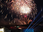 Wintteri-rakennus pimeällä sinisenä valaistuna ja taustalla ilotulituksia