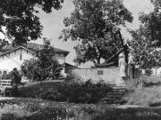 allimäen puistossa sijaitseva suuri rautainen purjelaivan ankkuri. Ankkuri on muistomerkki, jolla kunnioitetaan merenkulkijoita. Muistomerkin vierellä ihmisiä, taustalla näkyy Vallilan rakennus.Kesäaika.