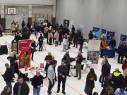 Ihmisiä sisäliikuntahallissa juttelemassa.