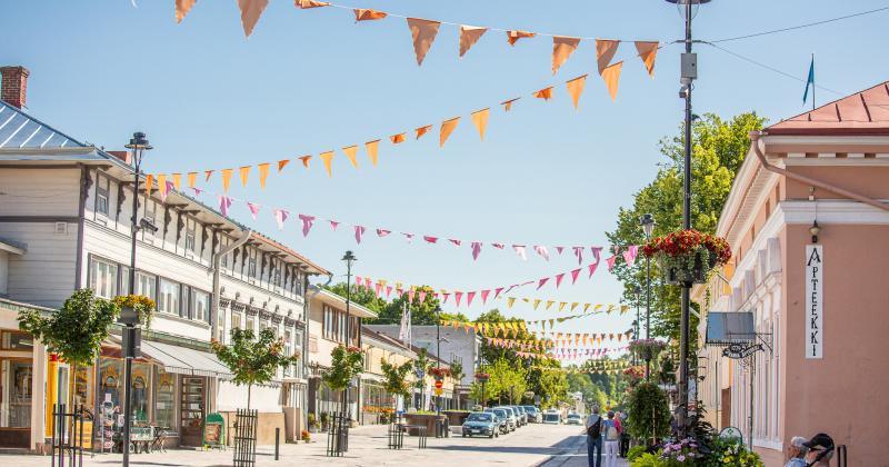 Alinenkatu kesällä 2023, värikkäät viirit auringossa kylpevän kadun yllä. 