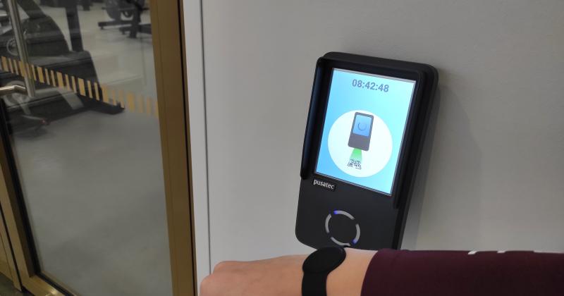 kädessä ranneke, lukulaitteen edessä