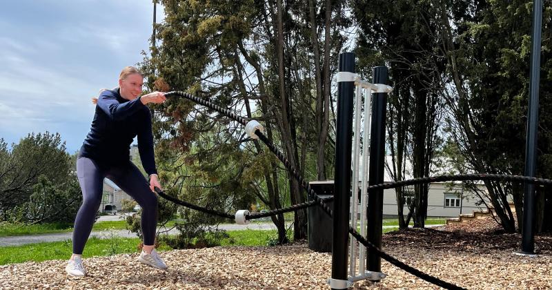 nainen treenaa ulkona voimaköysien kanssa
