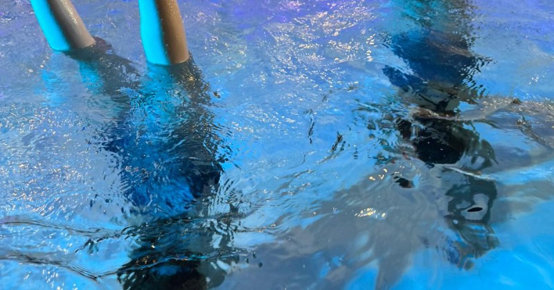 Lapset käsilläseisonnassa uima-altaassa